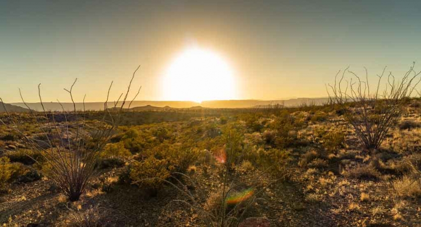 the sun sets behind a desert landscape in texas